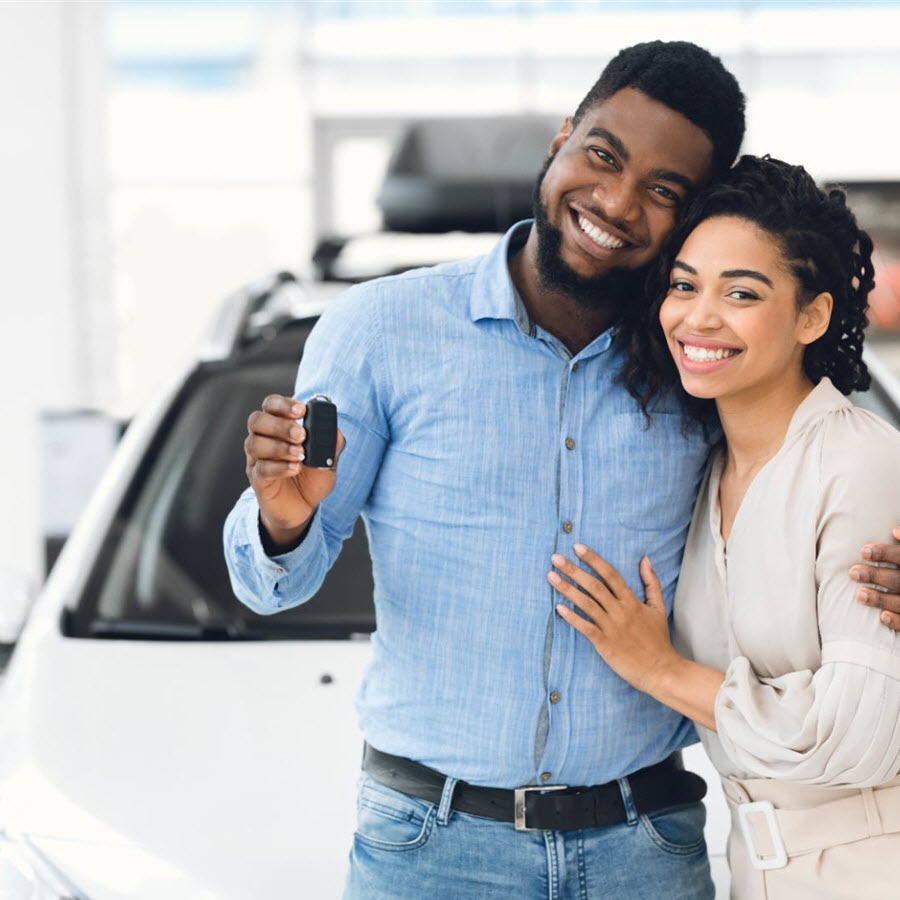 Happy Assiniboine Market Motors customers holding the keys to their new vehicle
